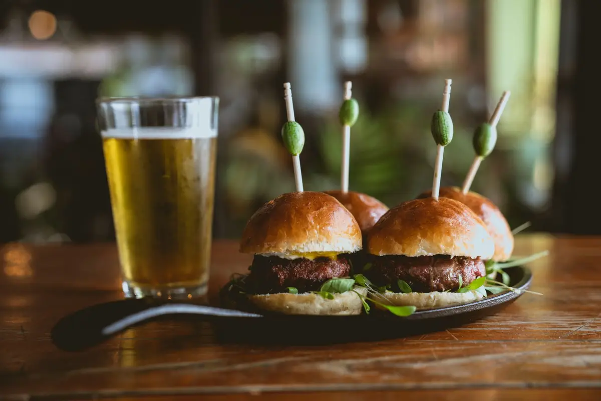 Beef sliders and a glass of beer on a bar and grill table