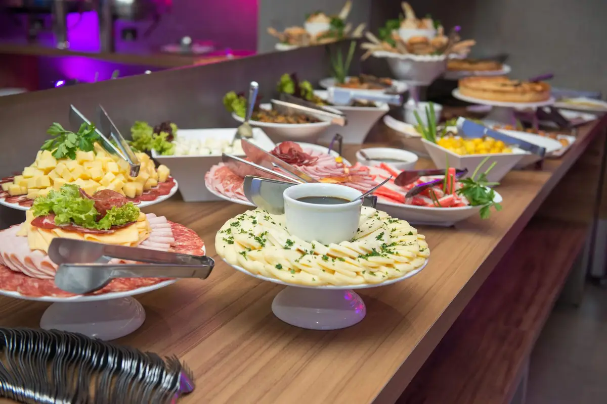 Buffet counter lined with dishes, salads and serving tongs